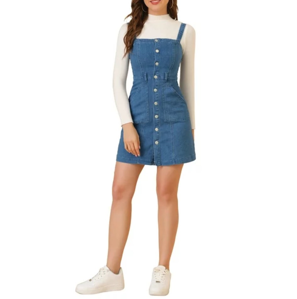Wanita dengan gaun denim dan atasan lengan panjang putih dengan sepatu kets putih