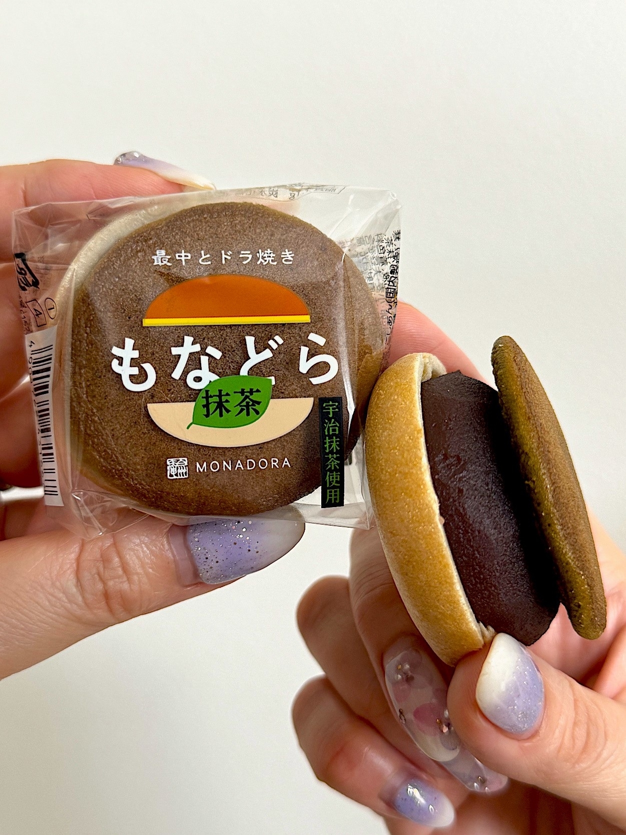 A person holding a packaged Japanese monaka wafer and one split open to show red bean filling