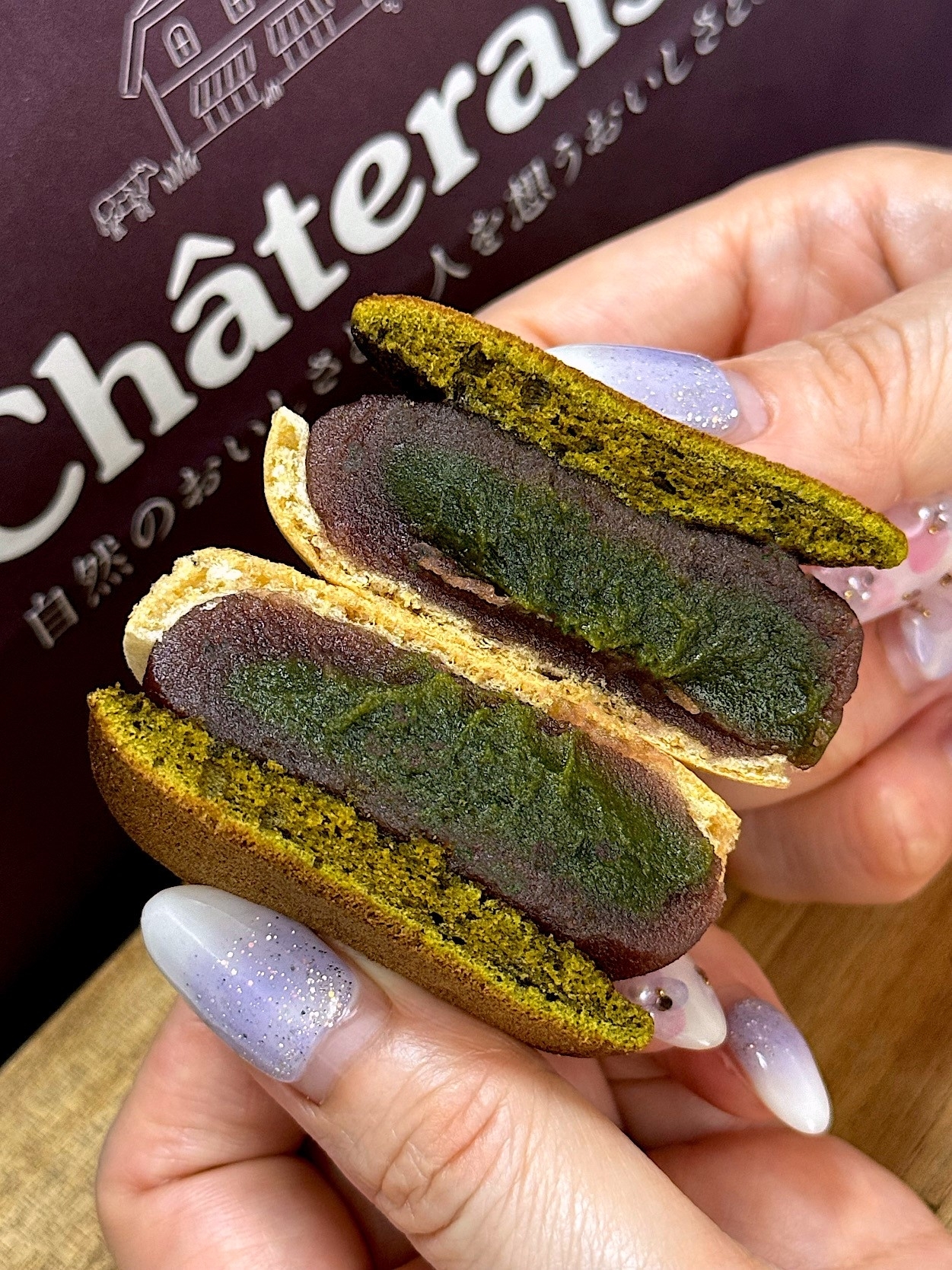 Person holding a matcha-flavored snack with a green tea filling