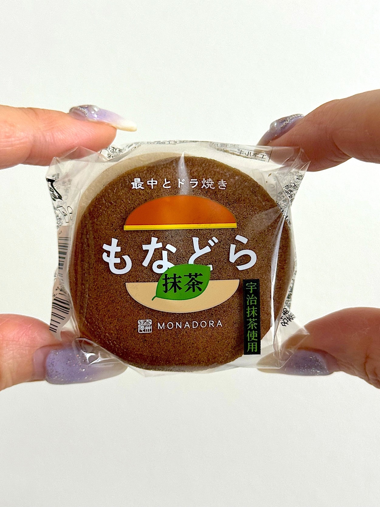 Hand holding a packaged Japanese Monaka wafer snack with visible text and branding