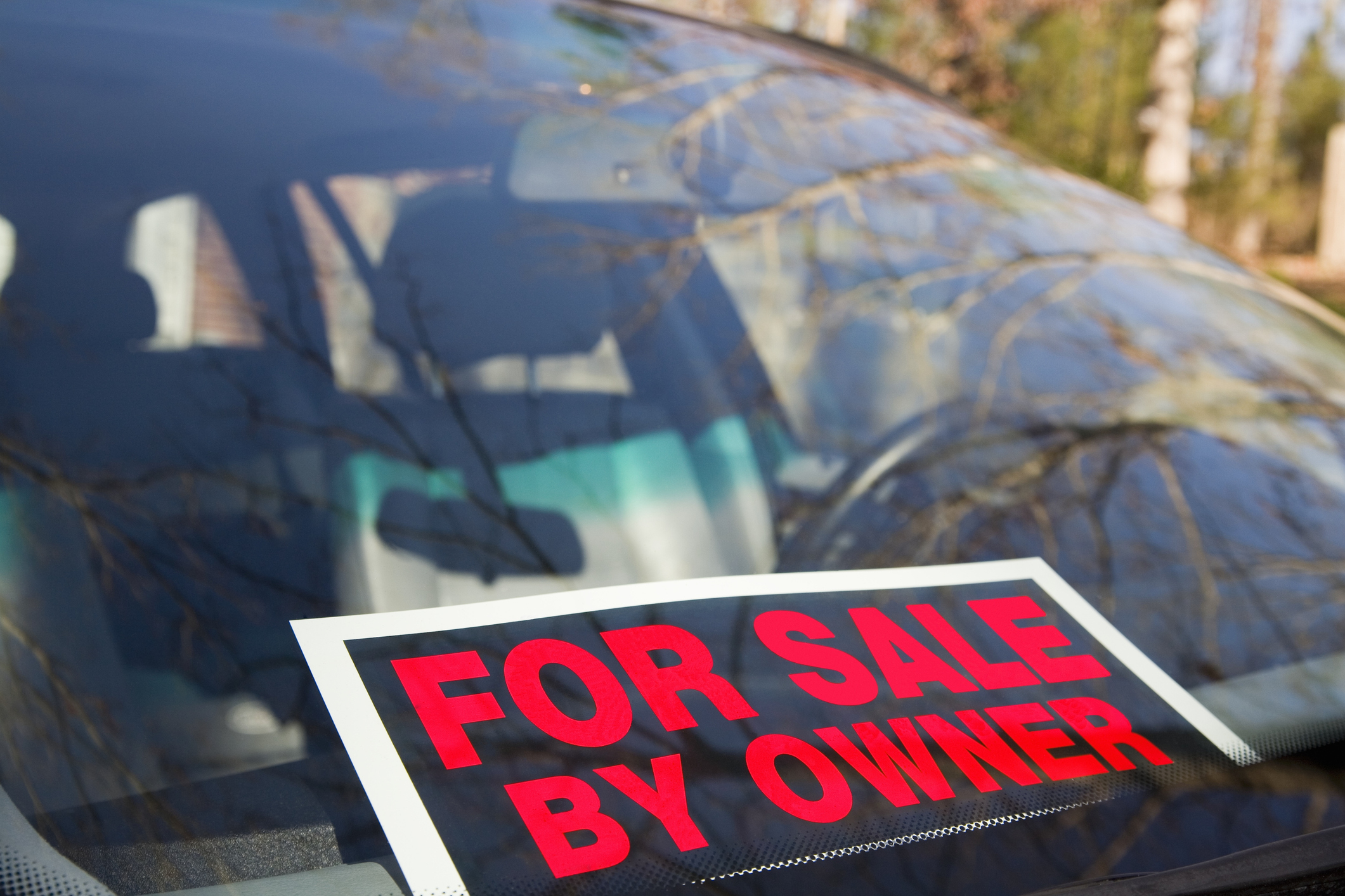 Sign on car windshield reads &quot;FOR SALE BY OWNER&quot;