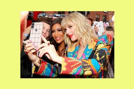 Taylor Swift taking a selfie with fans wearing a brightly patterned outfit