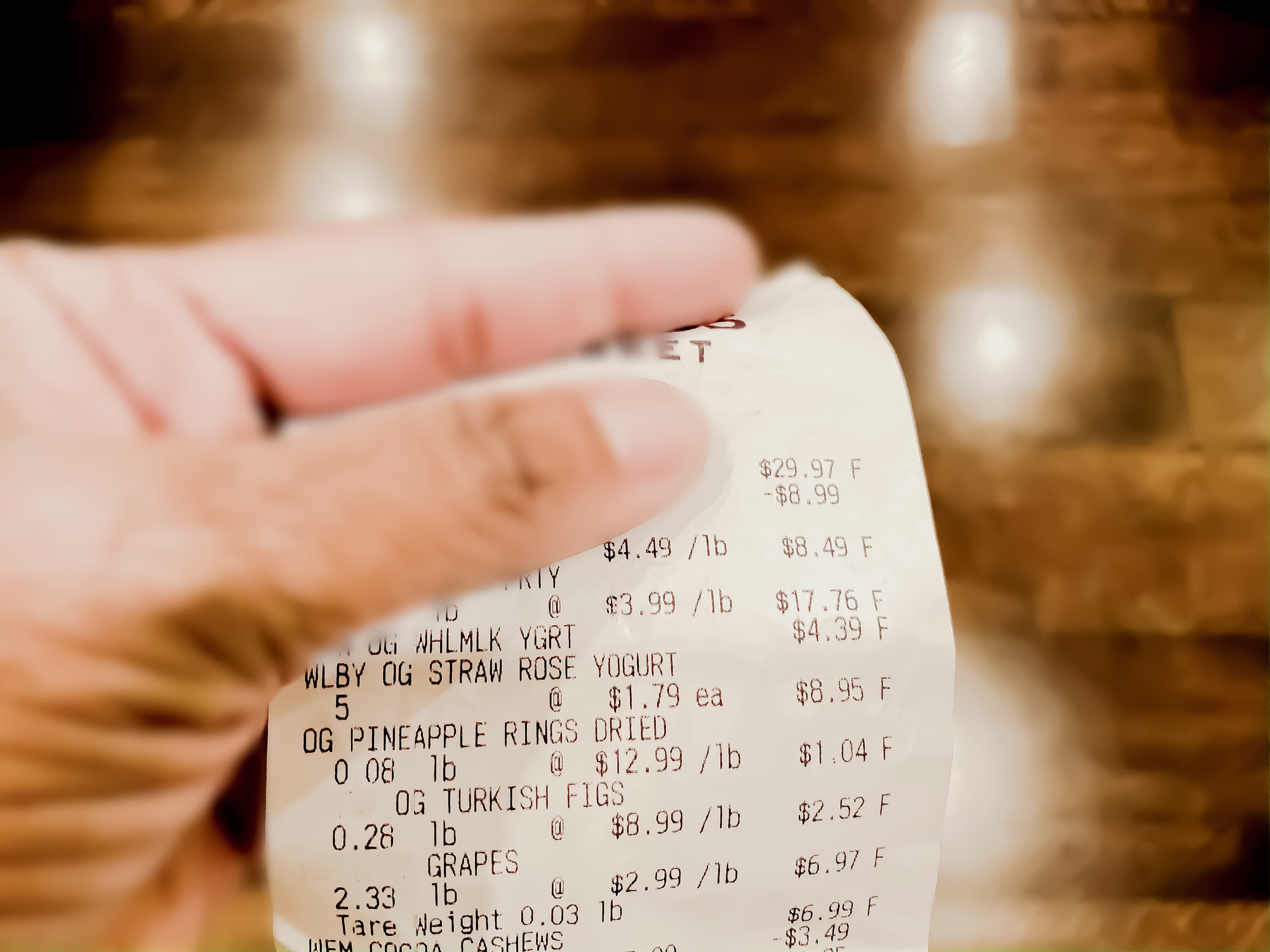 Person reviewing a grocery receipt, possibly managing household expenses