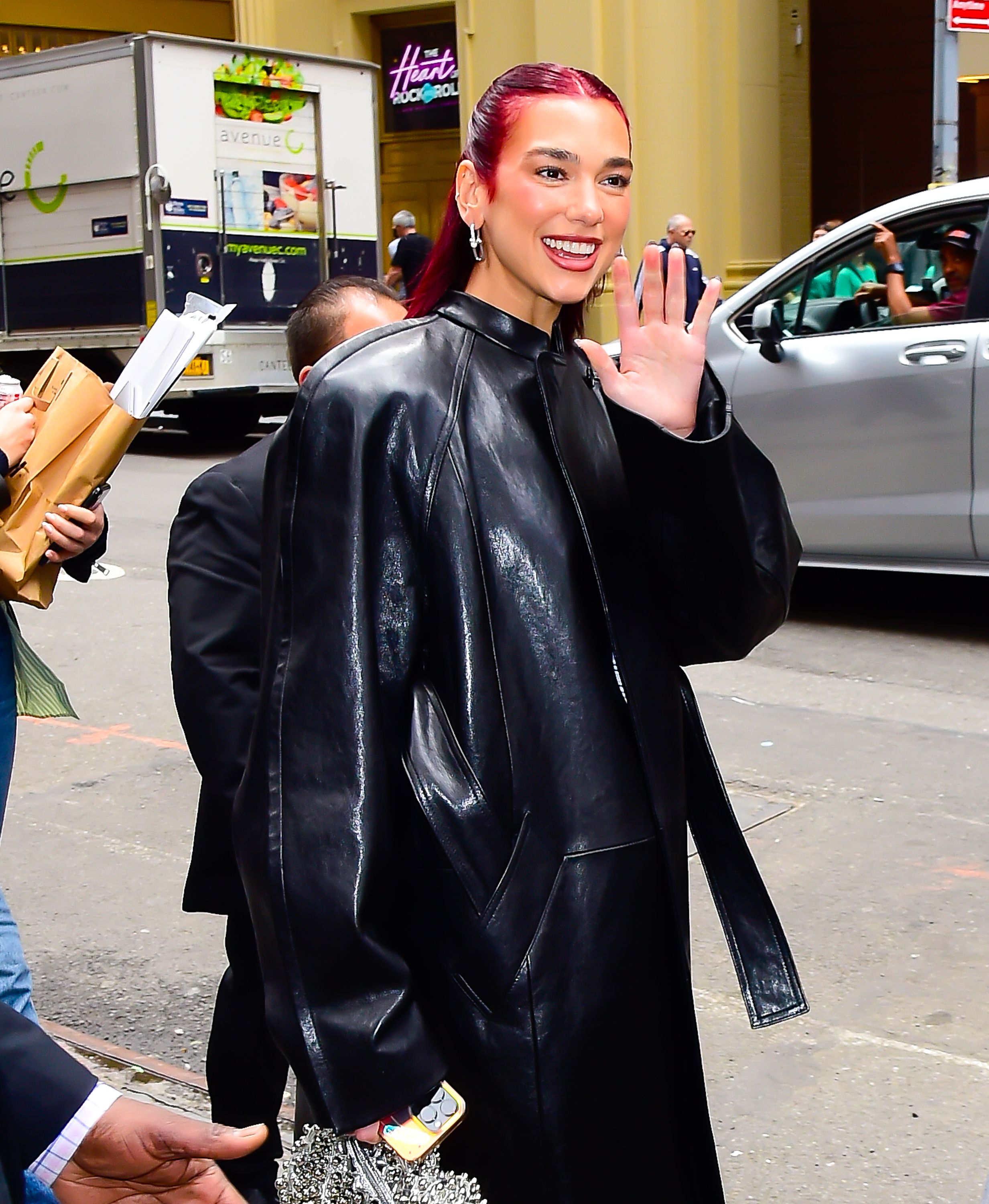 Woman in a black leather outfit waving