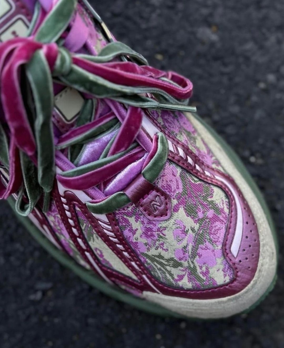 Close-up of a worn sneaker with floral pattern and frayed laces