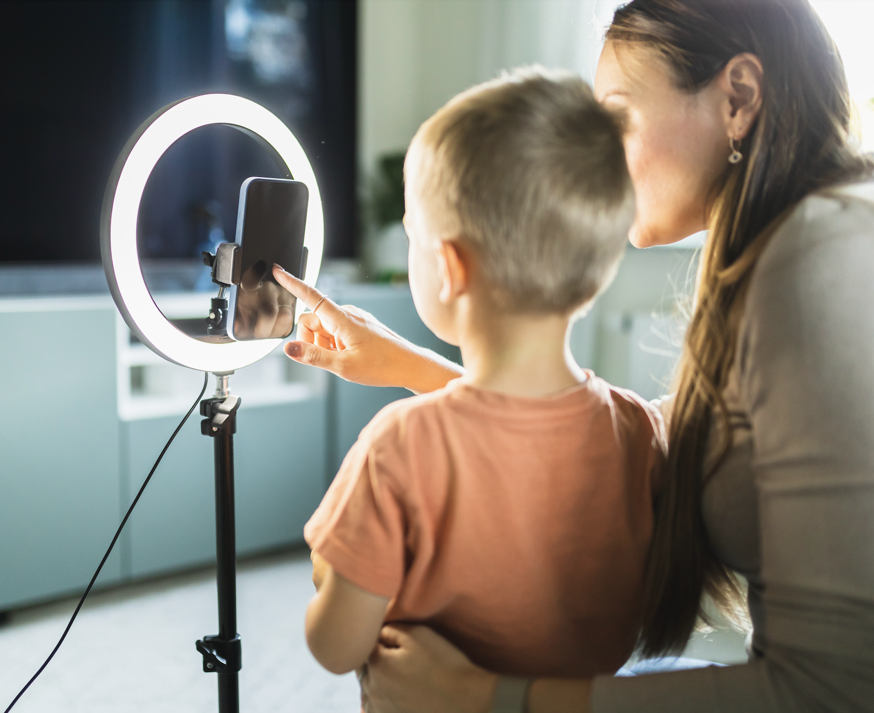 Woman and child making a video with a ring light and smartphone