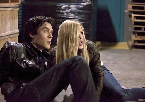 Two characters from the TV show &quot;The Vampire Diaries&quot;, a man and a woman, sitting closely and looking alert