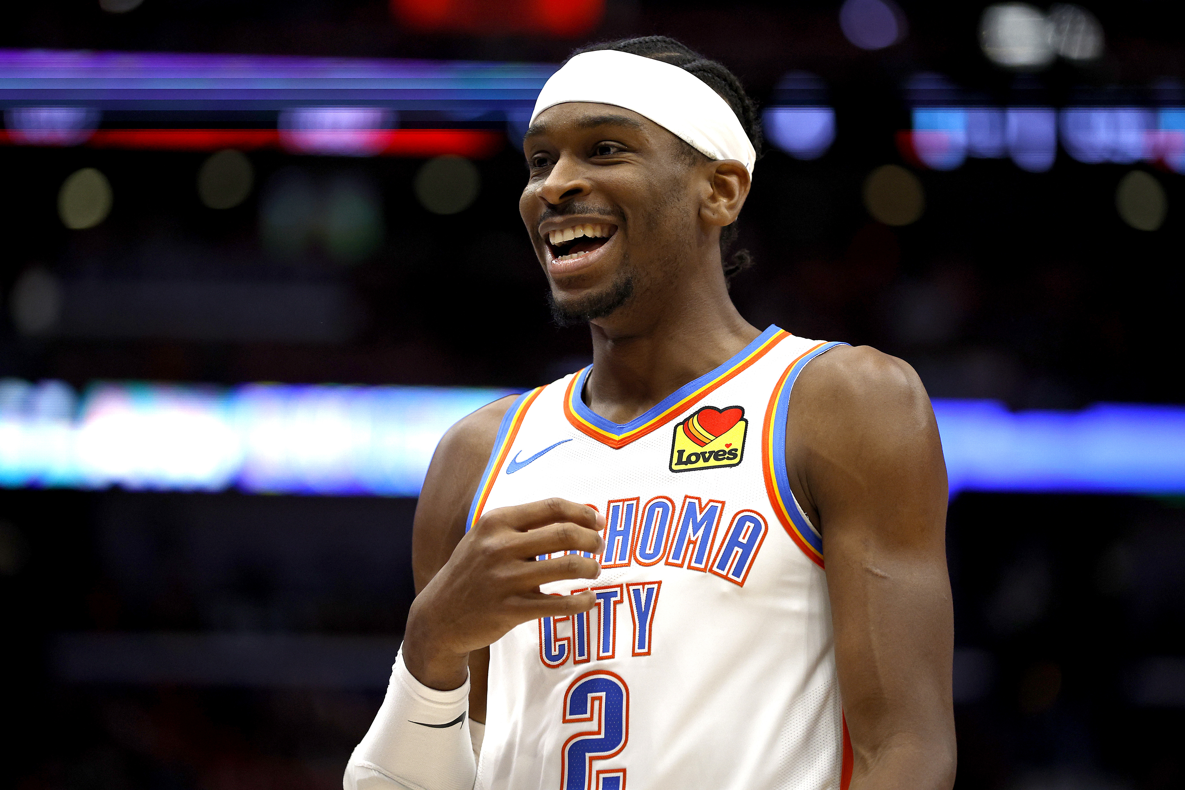 Basketball player in an Oklahoma City jersey, smiling with a headband on the court