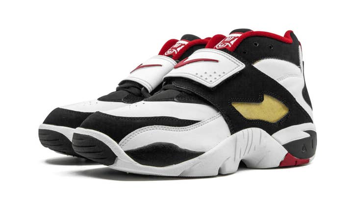 A pair of Nike Air Diamond Turf sneakers, side view, featuring a strap across the midfoot