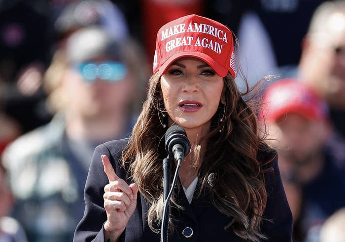 Kristi Noem wearing a MAGA hat during a speech