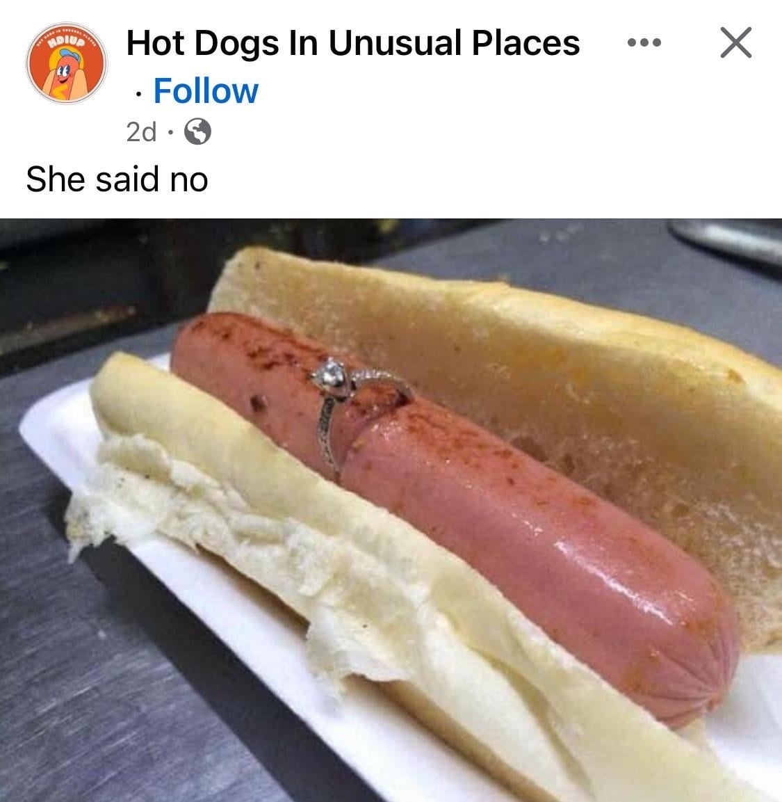 Engagement ring on a hotdog with a caption "She said no," from a social media post by Hot Dogs In Unusual Places