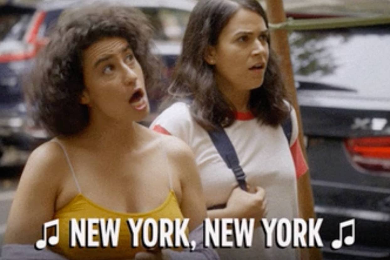 Two women appear surprised on a street, with musical notes and the caption "NEW YORK, NEW YORK."