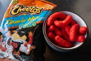 Flamin' Hot Cheetos Puffs package with a bowl of the snack beside it