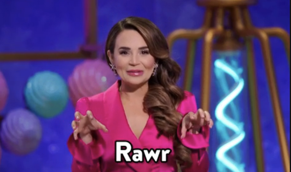 Woman in pink top makes claw gesture, speech bubble says &quot;Rawr&quot;