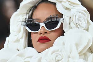 Person in avant-garde outfit with oversized flower details and dramatic eyelashes, wearing sunglasses