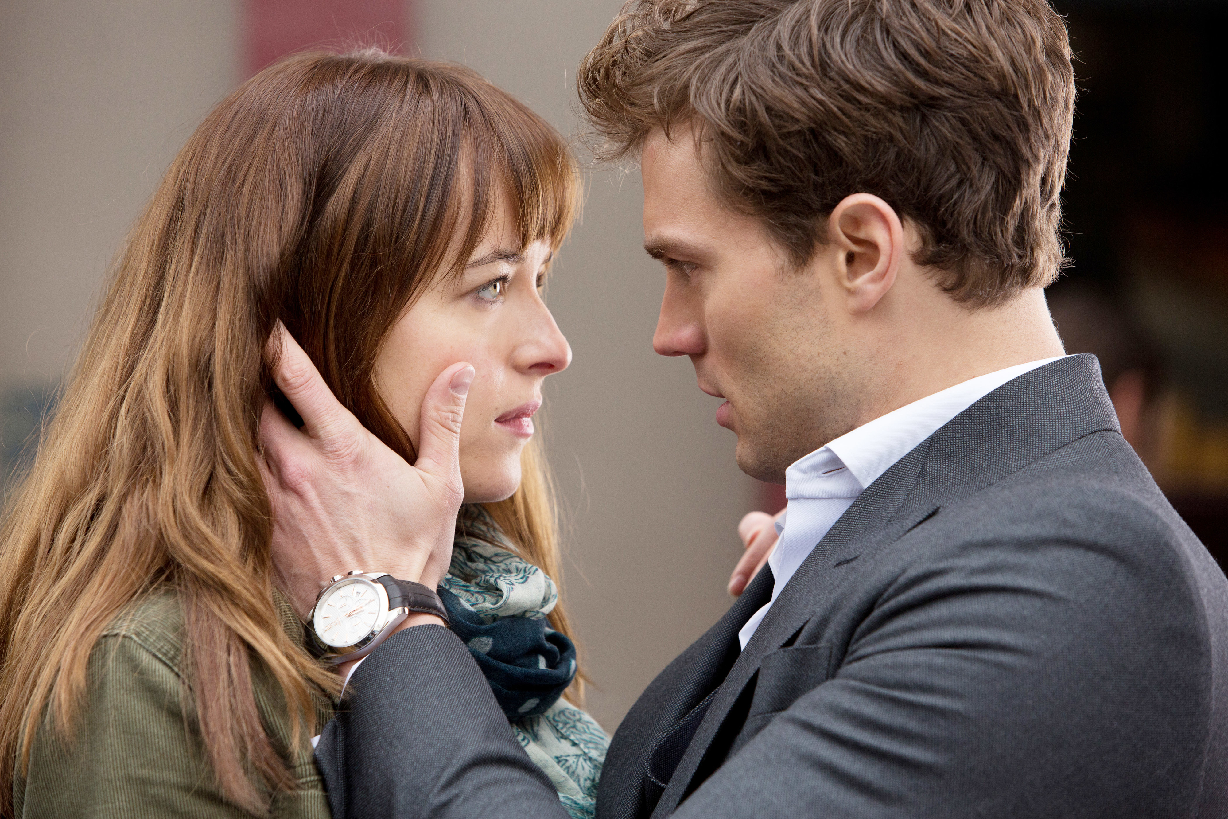 Anastasia Steele and Christian Grey stand close in a scene from Fifty Shades of Grey