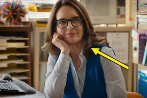 Tina Fey in Mean Girls leaning on hand, smiling, with a pointed arrow graphic added to the image