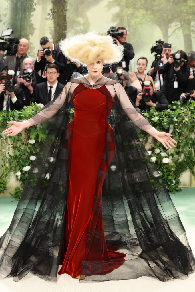 Gwendoline Christie in extravagant gown with photographers in background