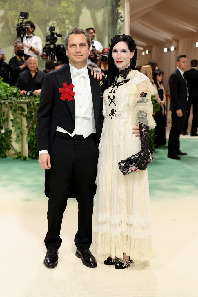 Harry in a suit with ribbon emblem, Jill in a lace-accented dress with shawl