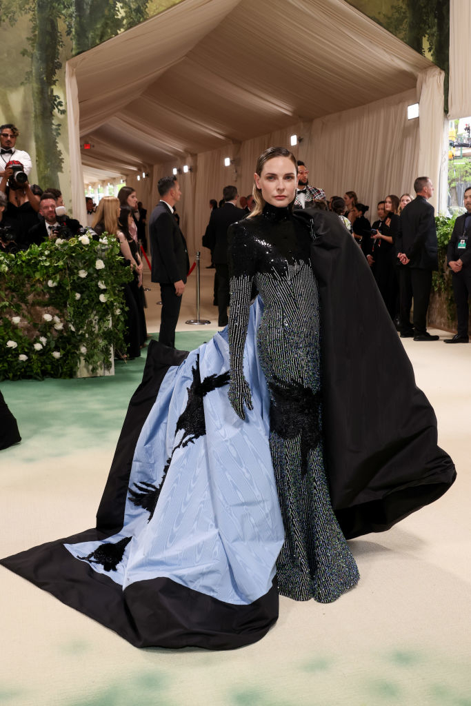 Rebecca Ferguson in a cape with blue underside and embellished black dress at a gala event