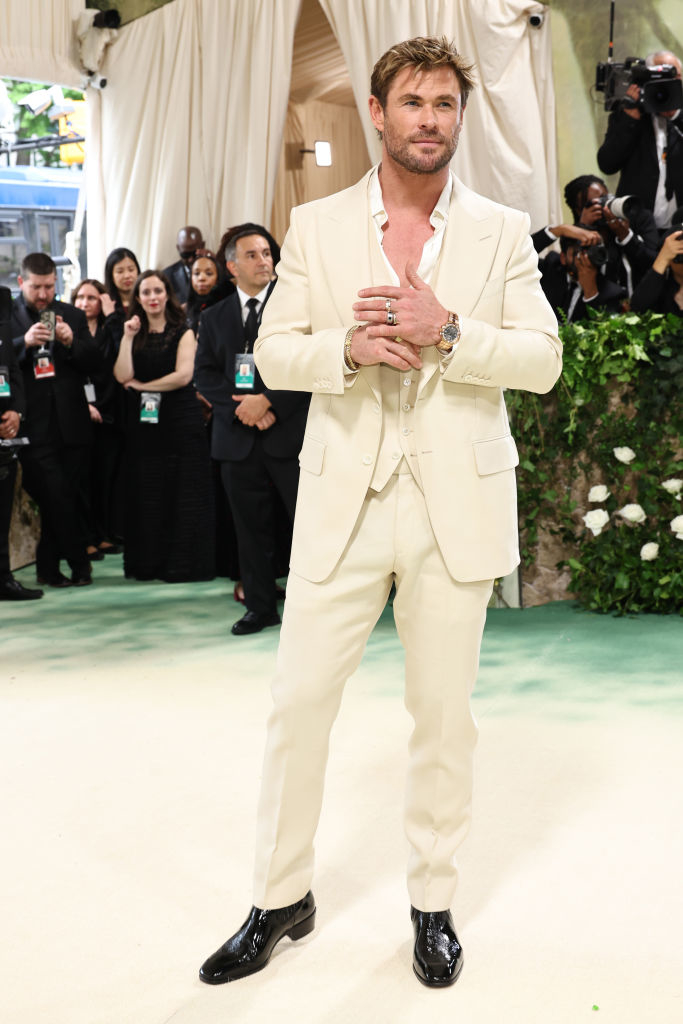 Chris Hemsworth in a cream suit with black shoes at a formal event