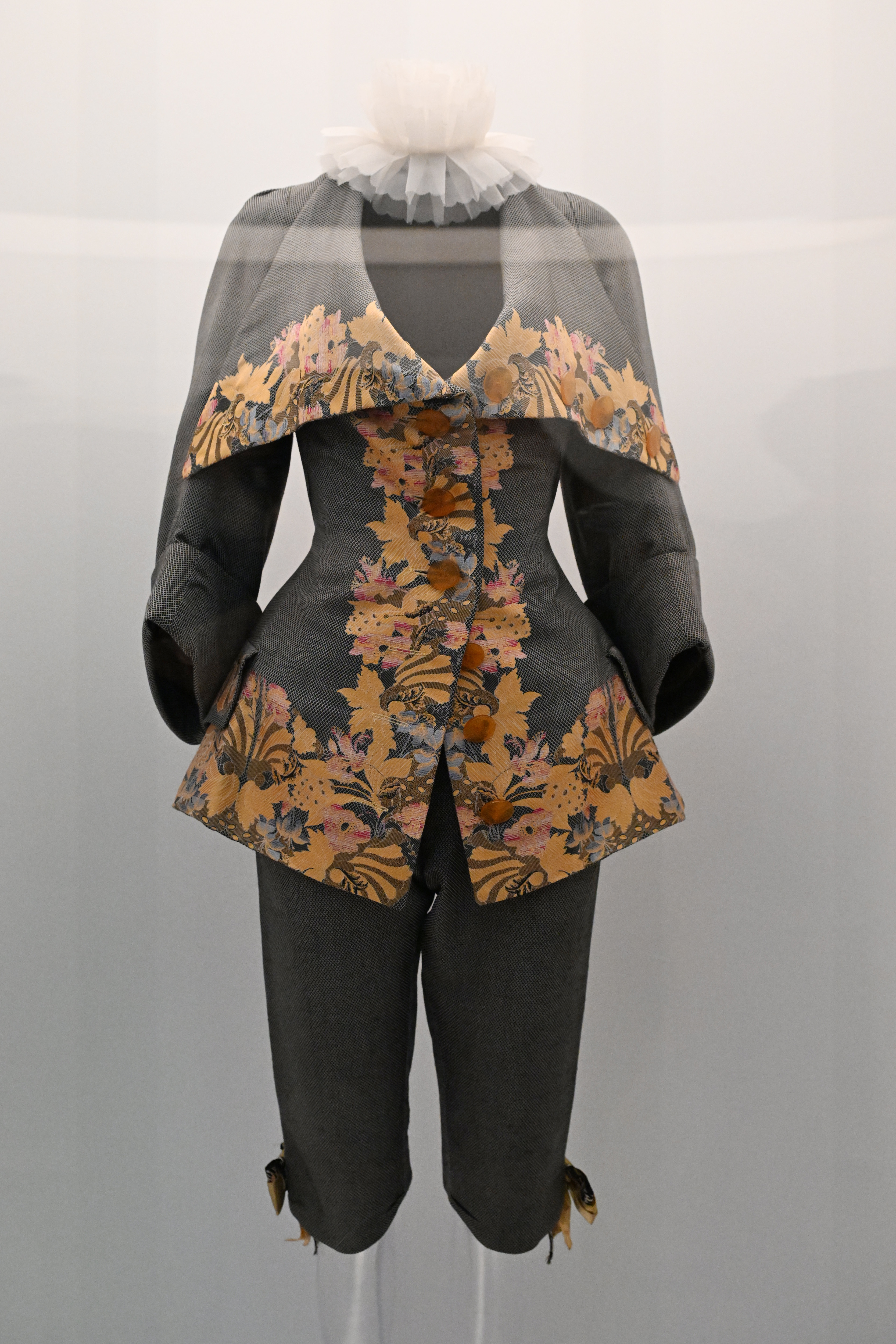 Vintage-style mannequin displaying a tailored jacket with floral accents and matching breeches