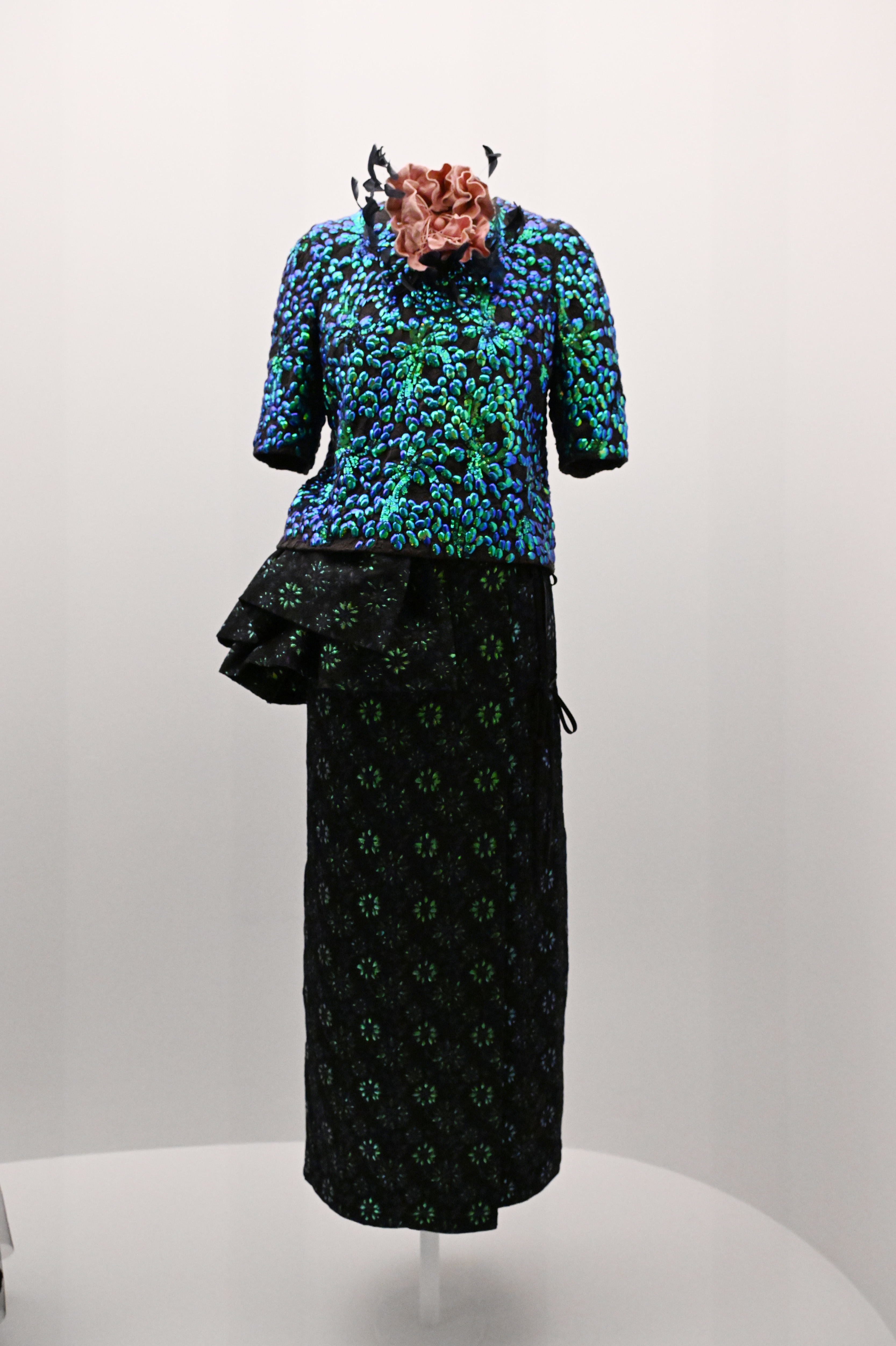 Sequin-embellished top with matching skirt on a mannequin, accessorized with a floral headpiece