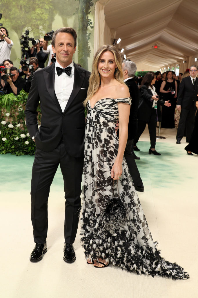 Seth in a tuxedo, Alexi in a floral off-shoulder gown with a train