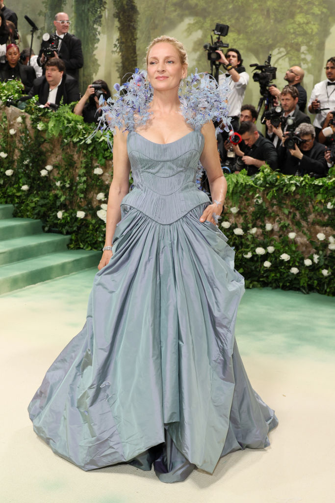 Uma Thurman in a voluminous gown with structured bodice and floral shoulder accents at an event
