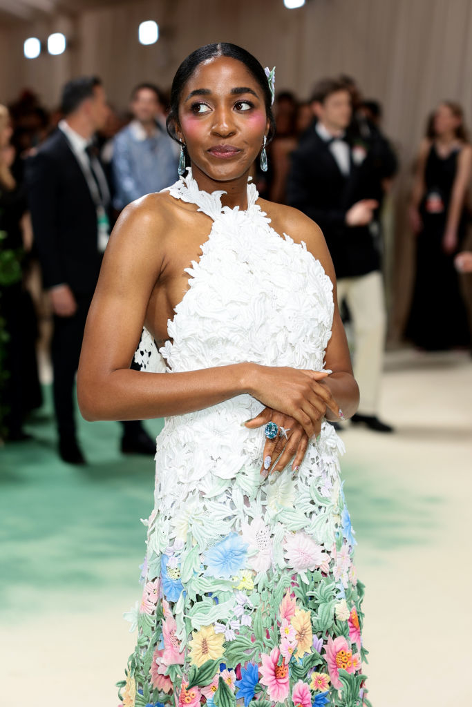 Ayo Edebiri in a floral-embellished white gown with a halter neckline at an event