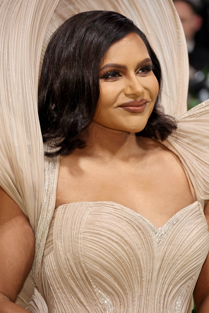 Mindy Kaling in a beige gown with a structured, ruffled shoulder detail