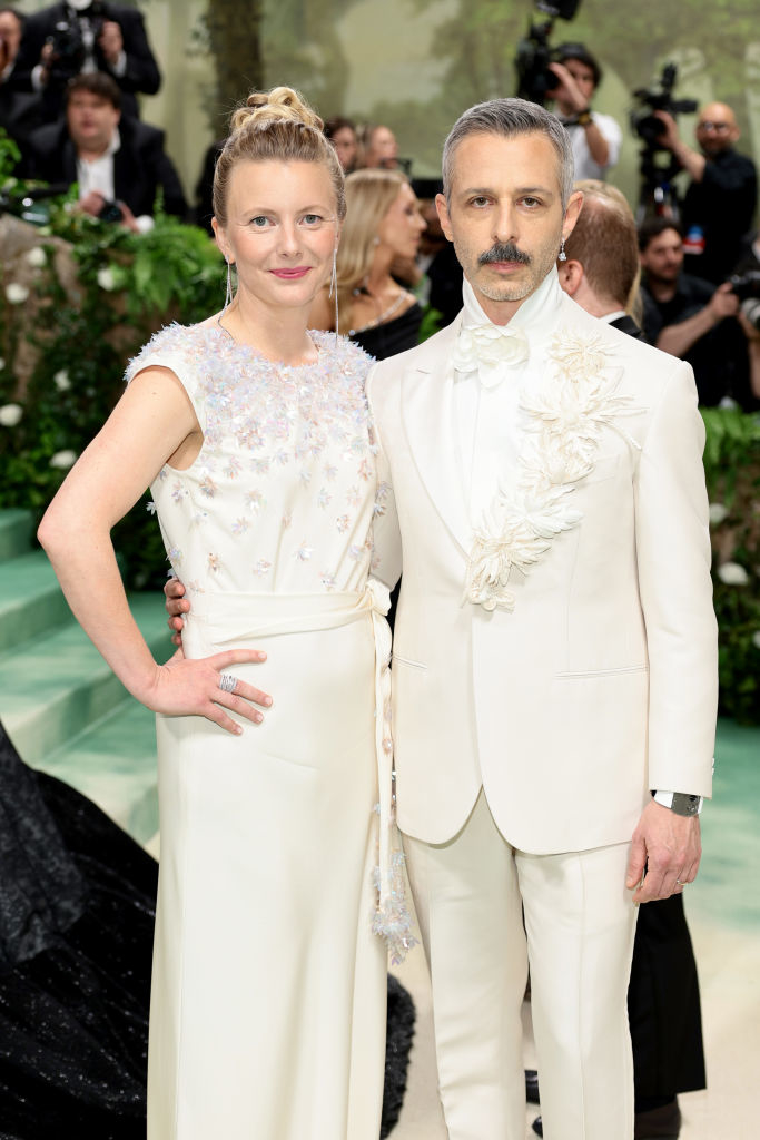 Emma Wall and Jeremy Strong wearing a floral-embellished dress, and a white suit