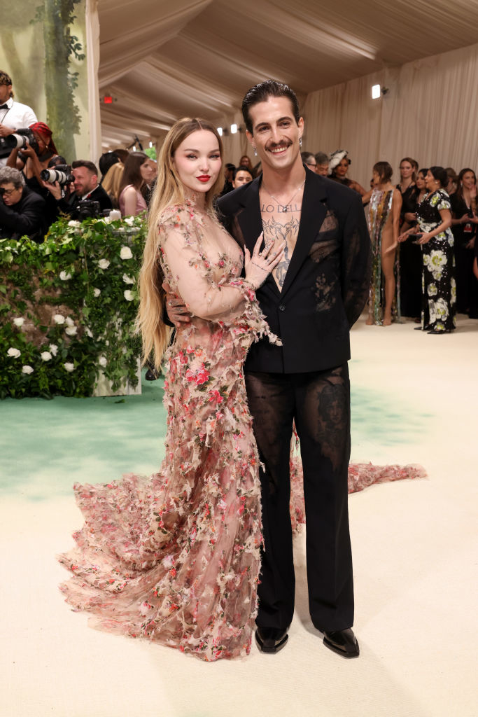 Dove in a floral gown, Damiano in a suit with sheer elements, posing together on the red carpet