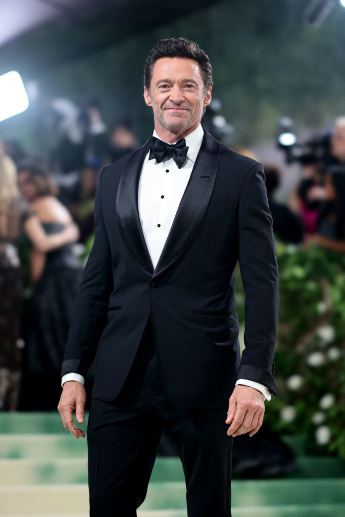 Hugh Jackman in a classic tuxedo with a bow tie, posing at an event
