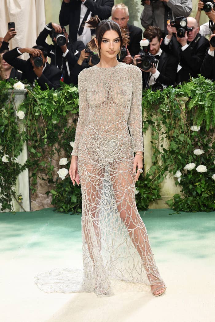 Emily Ratajkowski in a sheer, beaded gown with photographers in the background