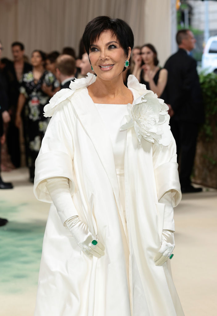 Kris Jenner in a white ruffled coat dress at a formal event