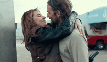 Two characters embracing and smiling, from the film &quot;A Star Is Born.&quot;