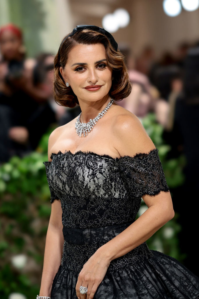Penélope Cruz in an off-shoulder lace gown with a diamond necklace at an event