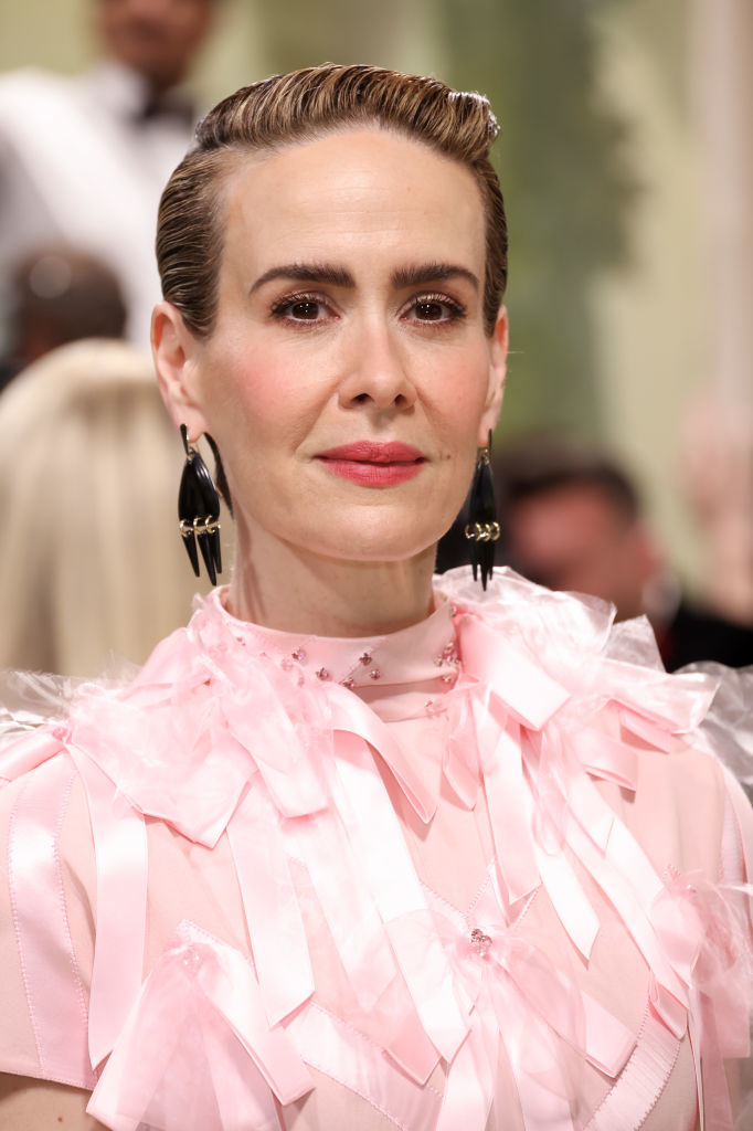 Sarah Paulson in pink ruffled attire with statement earrings at an event