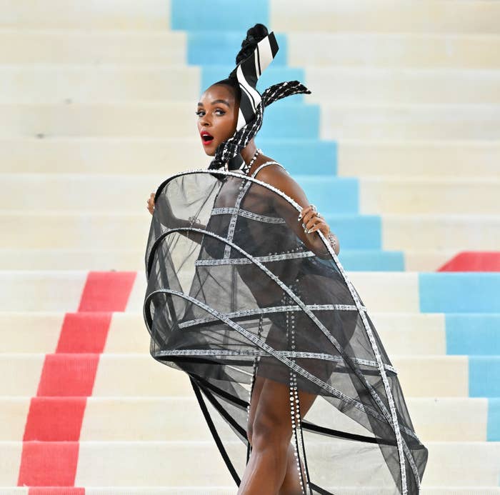 A person in an elaborate outfit with a headpiece posing on stairs