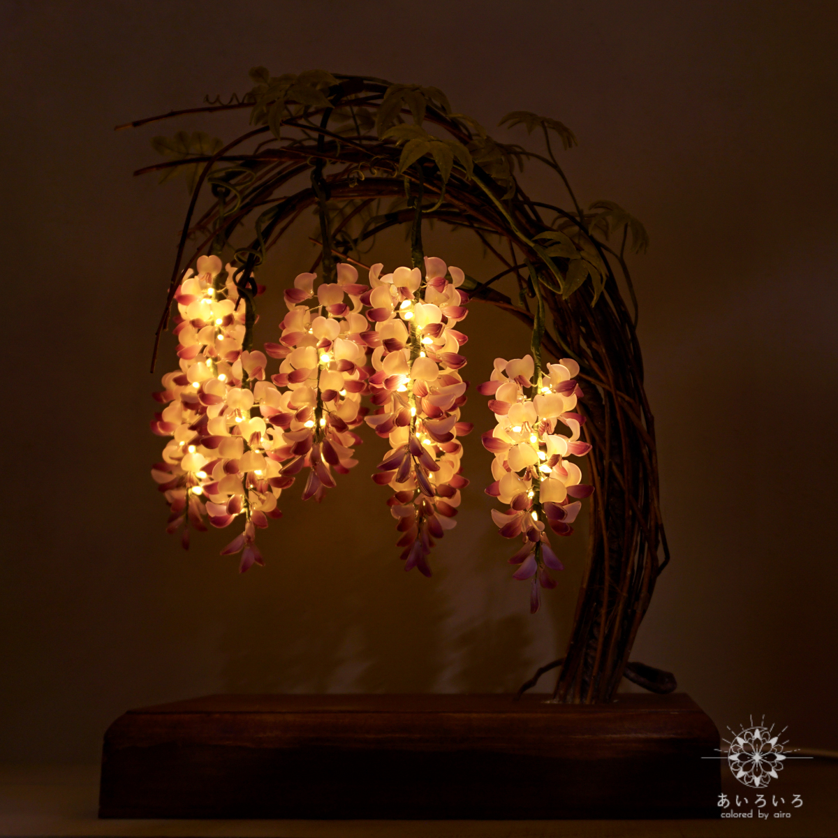 植物と花を模した照明器具が置かれた木製の台
