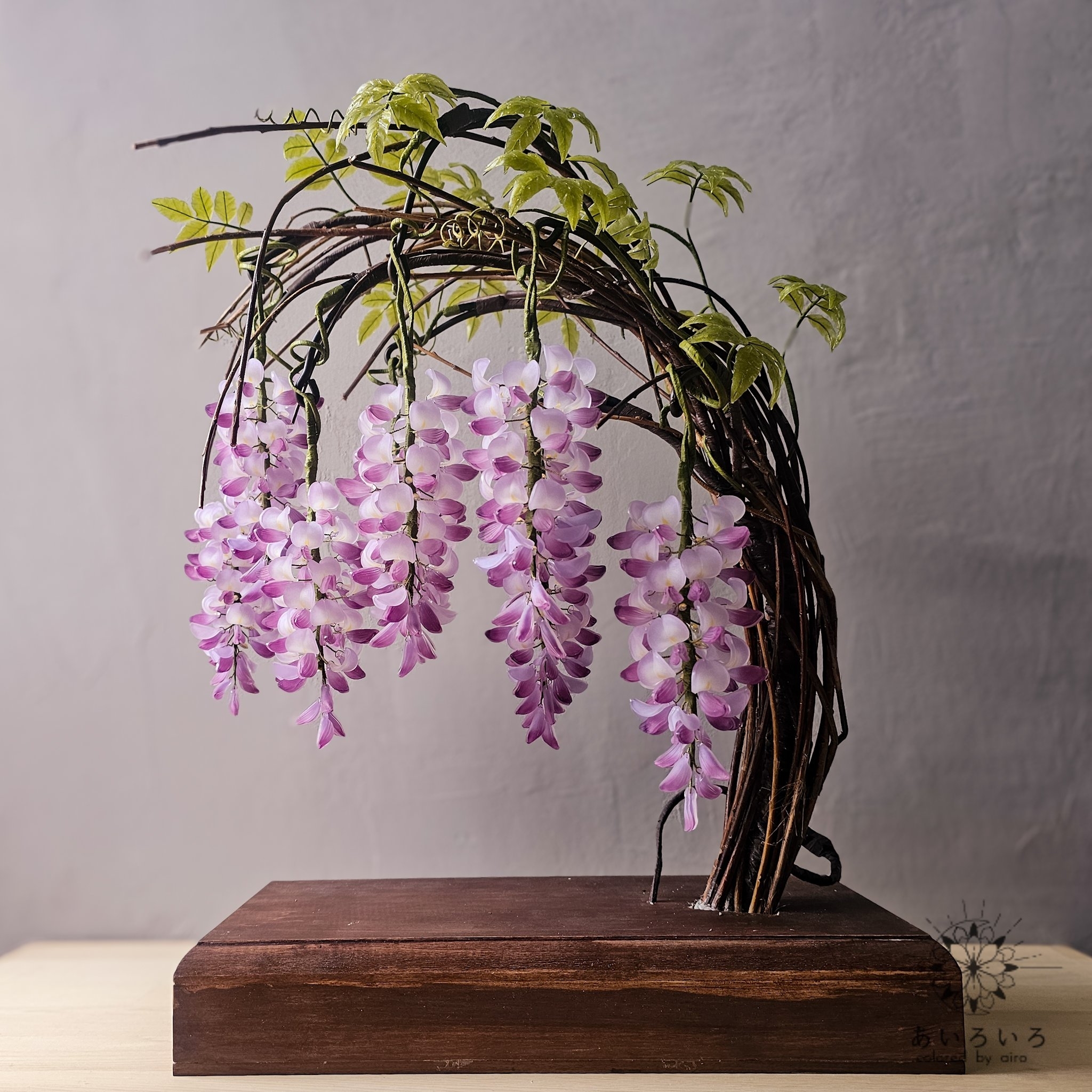 盆栽スタイルでアレンジされた紫の花が垂れ下がる植物のディスプレイです。