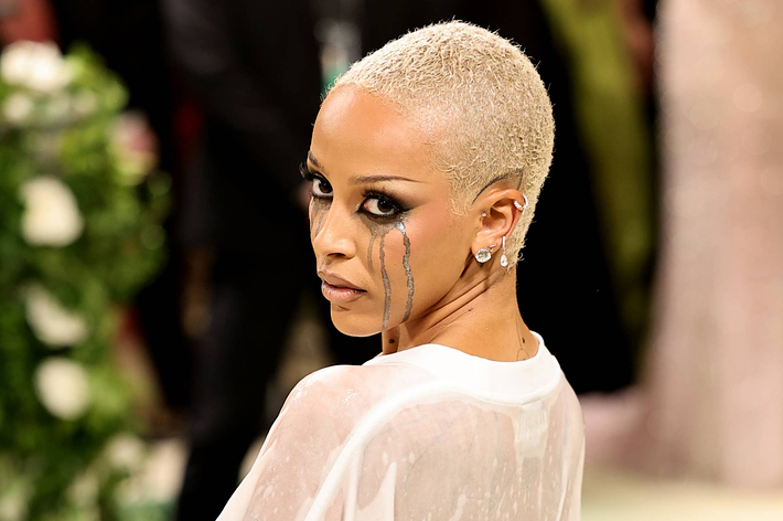 Woman with short hair in a sheer dress with teardrop crystals on her face