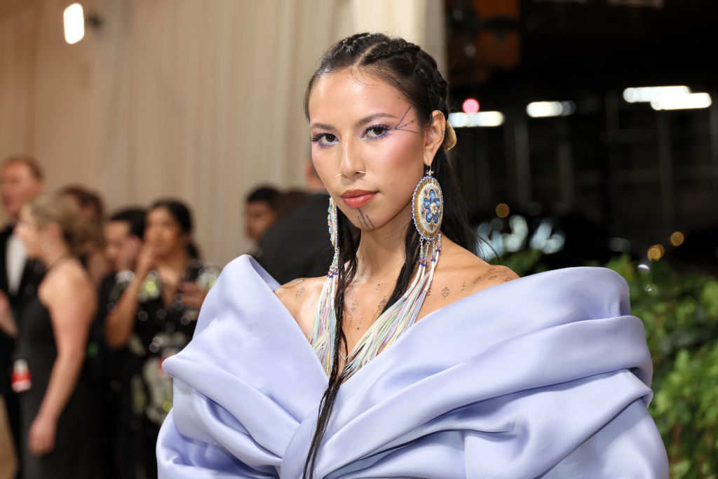 Quannah in a lavish puffed-sleeve gown with statement earrings