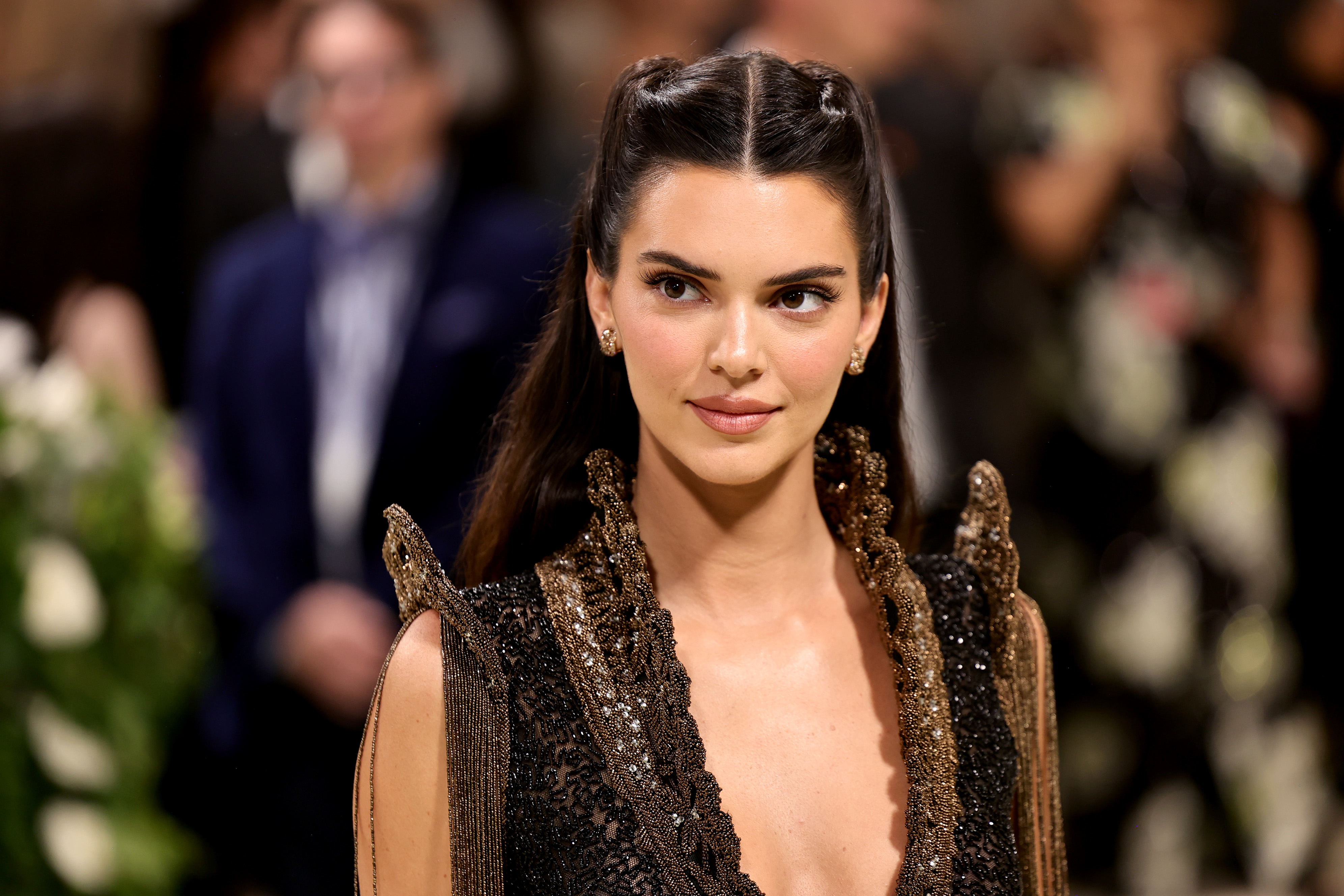 Kendall Jenner in a glittery gown with shoulder embellishments at an event