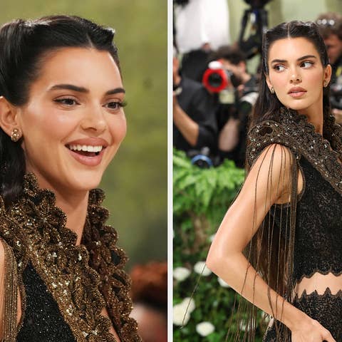 Kendall Jenner smiling in an ornate black dress with gold detailing at a gala event
