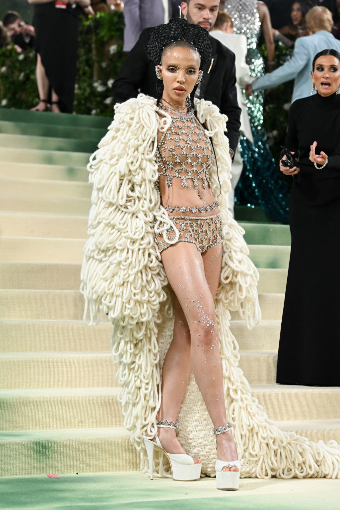 Rihanna wears a beaded and crystal-embellished ensemble with a bulky fringed coat at an event