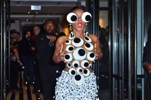 Woman in unique oversized circular glasses and polka-dot adorned outfit at an event