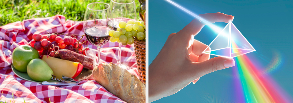 Picnic setup on a checkered blanket with various foods and a hand refracting light through a prism creating a rainbow