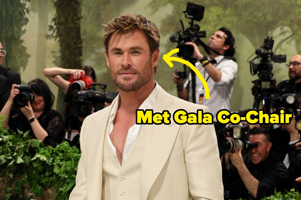 Man in a cream suit poses at an event; photographers in the background; text: "Met Gala Co-Chair"